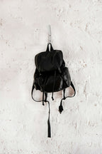 Black mini backpack hanging on a wall