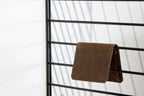 Brown leather bifold wallet on metal rack